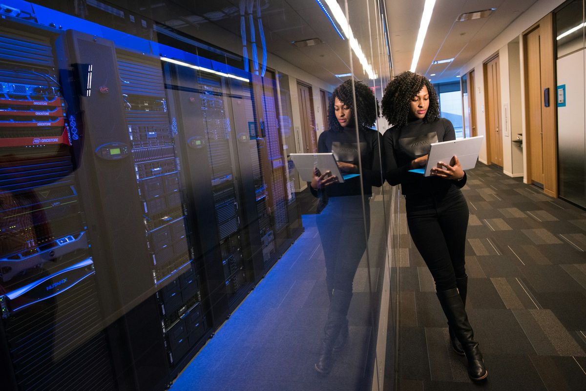 An engineer with a laptop in a server room