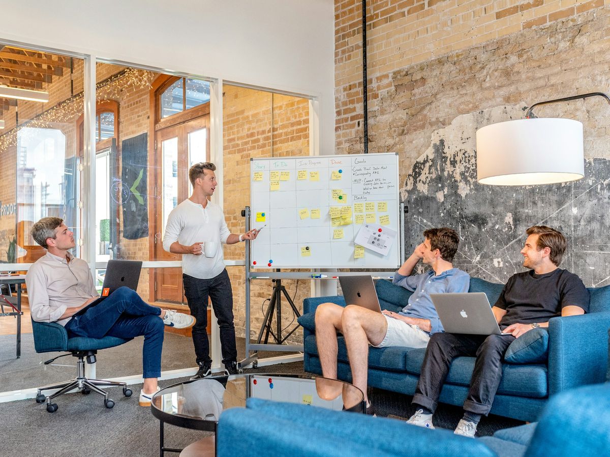 A team gathered on sofas for a presentation in a bright office