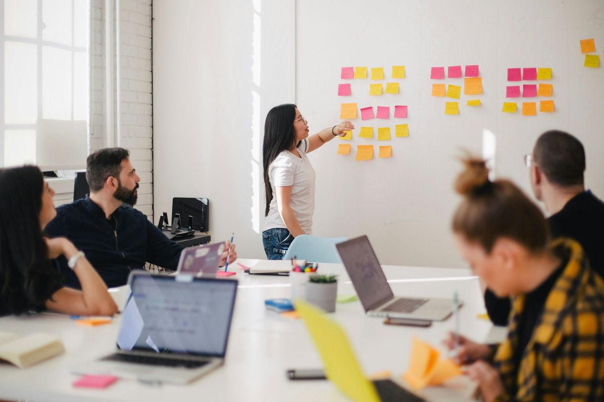 A team planning a project together with sticky notes on a glass wall