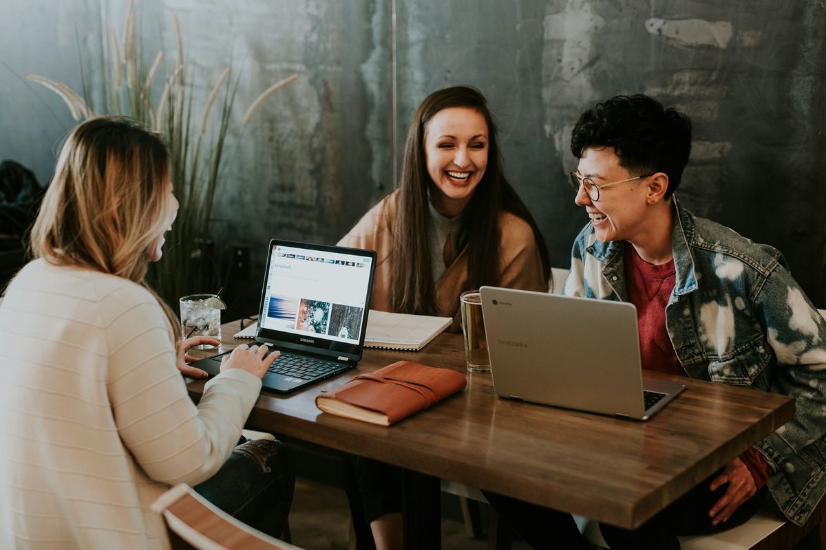 A team laughing together over a laptop